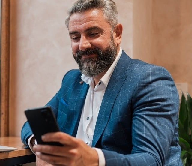 Imagen de un hombre mirando su teléfono móvil
