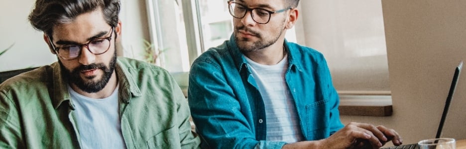 Imagen de dos amigos mirando unas notas