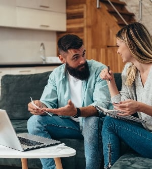 Imagen de una pareja joven planificando su presupuesto juntos en una computadora portátil en casa
