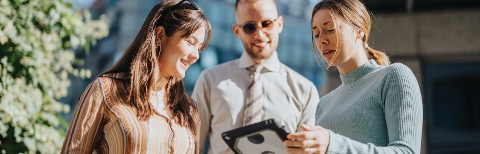 Imagen de un equipo corporativo que analiza las tendencias del mercado y la planificación estratégica en un entorno urbano mientras colabora con socios comerciales