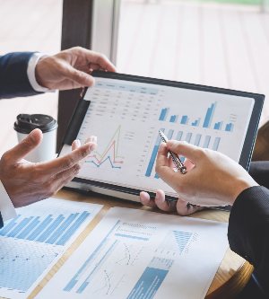 Imagen de dos compañeros de trabajando hablando sobre inversiones y crisis geopolíticas