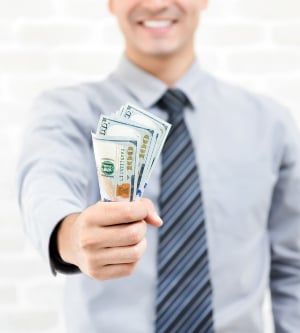 Imagen de un hombre con una cantidad elevada de billetes de dólares estadounidenses