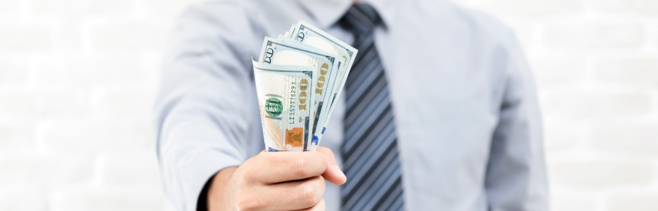 Imagen de un hombre con una cantidad elevada de billetes de dólares estadounidenses