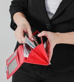 Imagen de una mujer sacando billetes de su cartera
