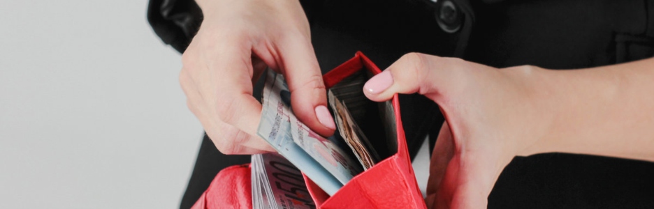 Imagen de una mujer sacando billetes de su cartera