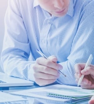 Imagen de dos personas repasando números sobre un papel