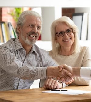 Imagen de una pareja cerrando un acuerdo con un gestor