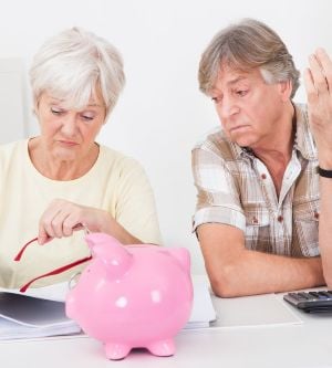 Imagen de una pareja de calculando el dinero para meter en la hucha de ahorro