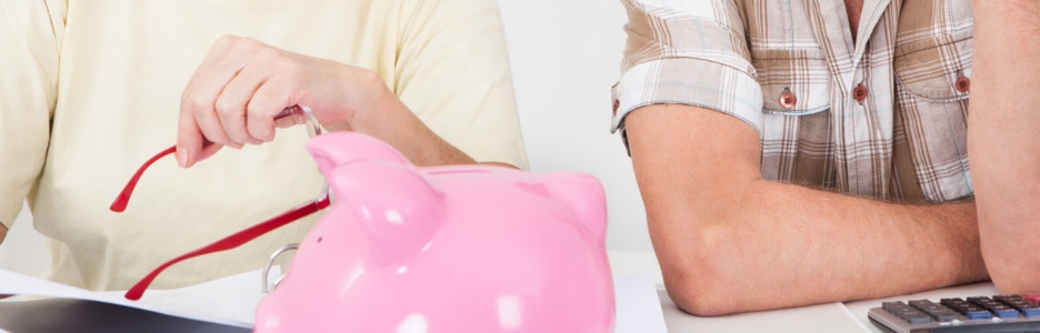 Imagen de una pareja de calculando el dinero para meter en la hucha de ahorro