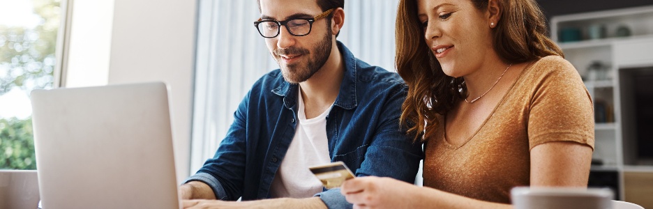 Imagen de ella conoce todos los mejores sitios web con grandes ofertas especiales. Una pareja joven hace algunas compras en línea en una computadora portátil juntos durante el fin de semana en casa