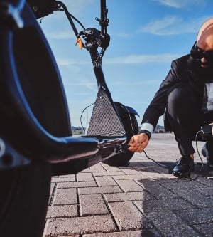 Imagen de una persona cargando su patinete eléctrico