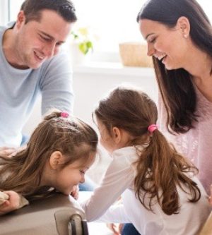 Imagen de una familia de cuatro jugando en el salón de una casa