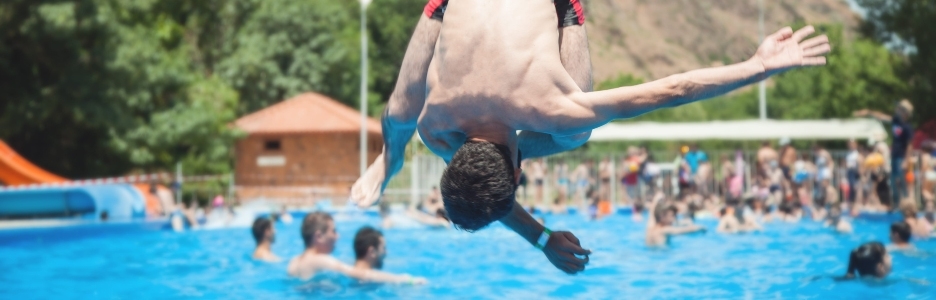 Imagen de un hombre saltando en el agua de la piscina