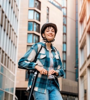 Imagen de una mujer con su patinete eléctrico