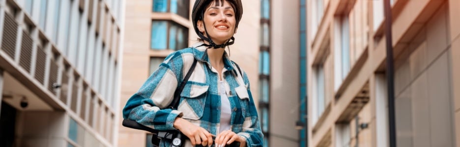 Imagen de una mujer con su patinete eléctrico