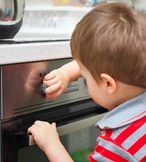 Imagen de un niño en la cocina encendiendo el horno sin supervisión de sus padres