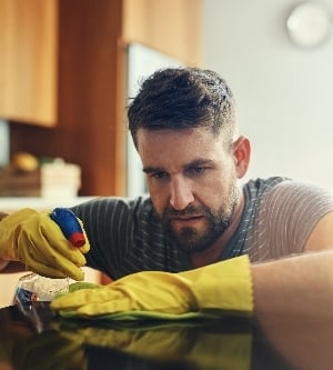 Imagen de hombre con actitud de no hay gérmenes bajo mi vigilancia. un joven limpiando el mostrador de la cocina en casa