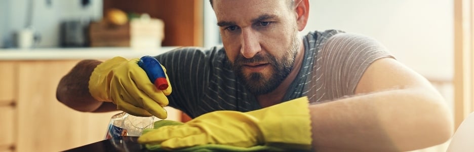 Imagen de hombre con actitud de no hay gérmenes bajo mi vigilancia. un joven limpiando el mostrador de la cocina en casa