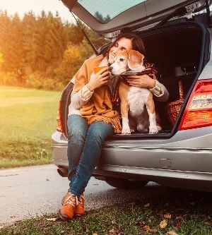 Imagen de una mujer abrazando a su perro en su coche