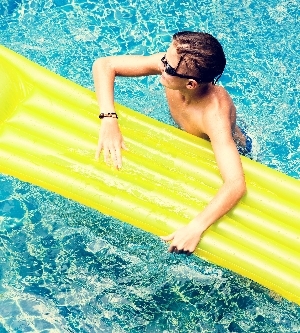 Imagen de un niño joven caucásico disfrutando de la piscina