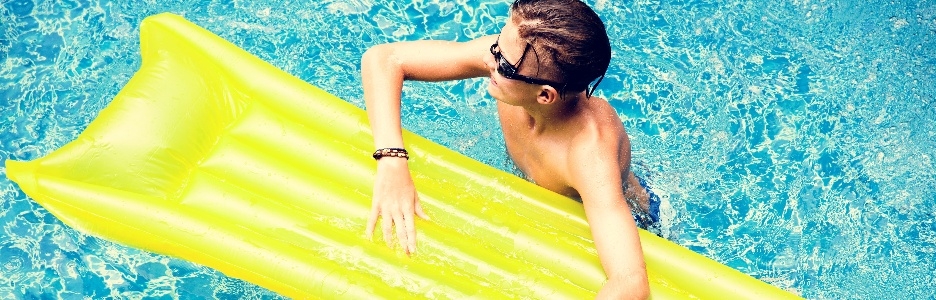 Imagen de un niño joven caucásico disfrutando de la piscina