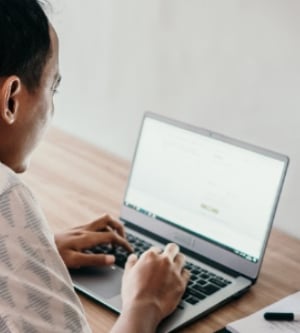 Imagen de una persona teletrabajando con su ordenador portátil