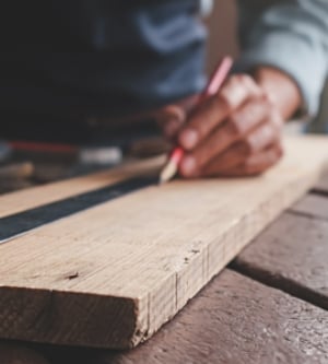 Imagen de una persona midiendo una tabla de madera
