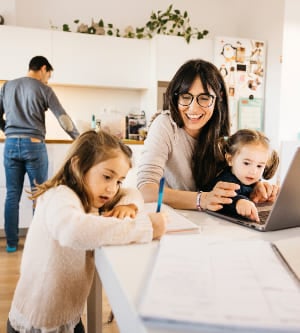 Imagen de una familia en el salón - comedor mientras la madre teletrabaja