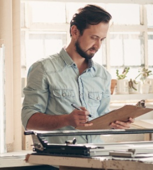 Imagen de un hombre completamente su lista de tareas en su portapapeles