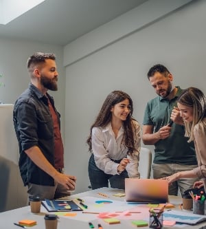 Imagen de un equipo feliz de negocios trabajando juntos en una reunión informativa corporativa reunida en la mesa en la sala de conferencias mientras usa una computadora portátil. colegas sonrientes en una sala de juntas discutiendo negocios juntos.