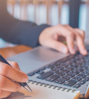 Imagen de una persona tomando notas con su ordenador portátil