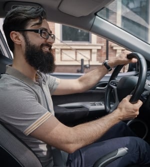 Imagen de un hombre joven conduciendo su coche