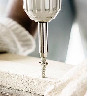 Imagen de un destornillador eléctrico sobre una tabla de madera