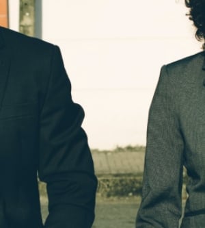 Imagen de dos profesionales en traje caminando juntos