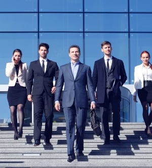 Imagen de un grupo de profesionales en trajes delante del lugar de trabajo