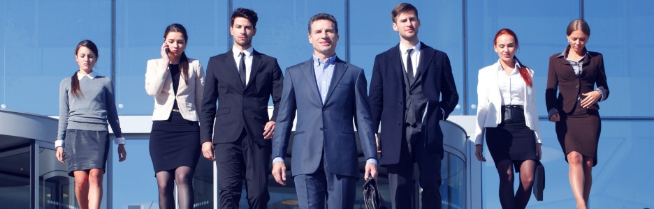 Imagen de un grupo de profesionales en trajes delante del lugar de trabajo