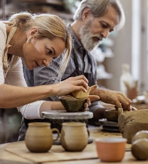 Imagen de manos artesanos haciendo tazas de arcillas rojas
