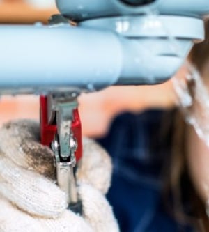 Imagen de un fontanero técnico con una llave para reparar un tubo de agua bajo el lavabo