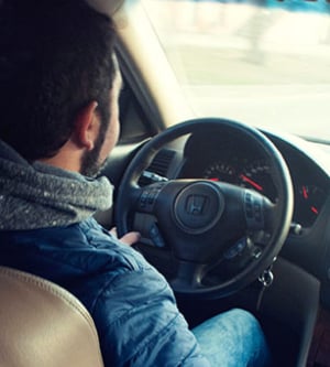 Imagen de un hombre conduciendo su coche para hacer la ITV (significa Inspección Técnica de Vehículos)