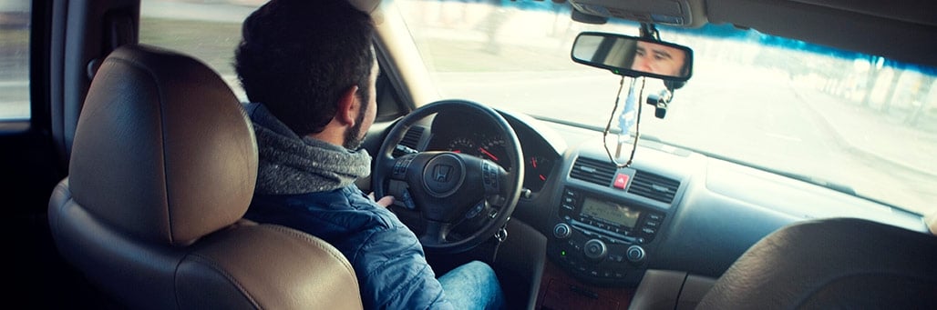 Imagen de un hombre conduciendo su coche para hacer la ITV (significa Inspección Técnica de Vehículos)