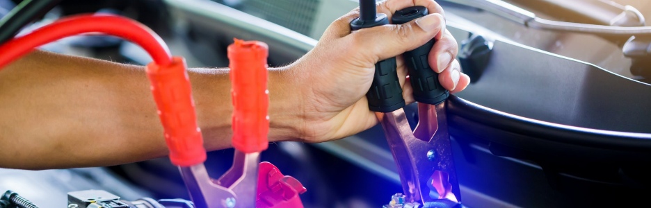 Imagen de un hombre arrancando su coche con pinzas