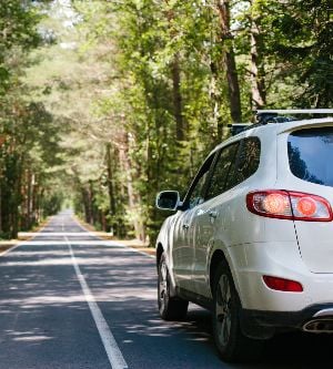 Imagen de un coche de color blanco circulando por una carretera