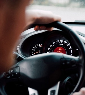 Imagen de un conductor viaja en el auto detrás de la vista del volante desde el asiento trasero. El conductor al volante del coche.