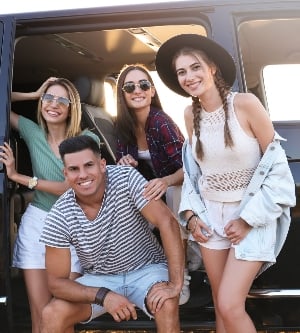 Imagen de un grupo de jóvenes posando en frente de una furgoneta