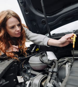 Imagen de una mujer cambiando el aceite de su coche