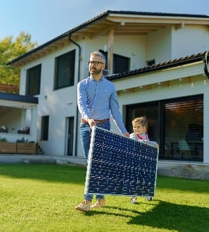 Imagen de padre con su pequeña hija llevando paneles solares en su patio trasero recursos alternativos de ahorro de energía y concepto de estilo de vida sostenible