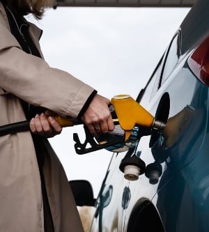 Imagen de una mujer bombeando gasolina en el surtidor de gasolina la mujer reposta el coche una mujer en una gasolinera una mujer llena un coche con gasolina en una gasolinera inyección de combustible en el tanque detalle de una mujer llenando un coche con combustible diésel