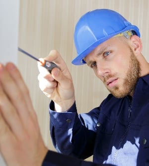 Imagen de un trabajador instalando una ventana con un tornillo