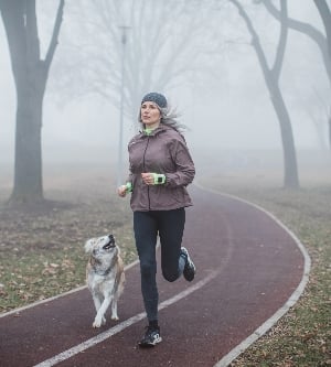 Imagen de una mujer haciendo footing acompañada de su perro