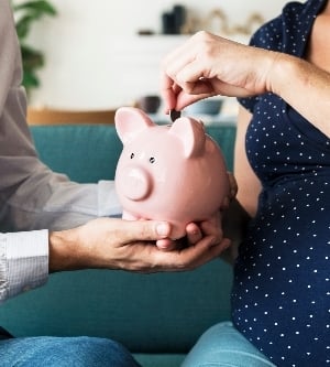 Imagen de una pareja ahorrando con una piggy bank (alcancía)